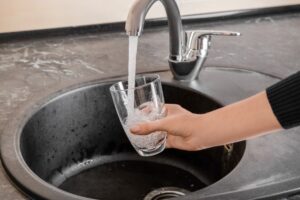 Person füllt Glas mit Leitungswasser